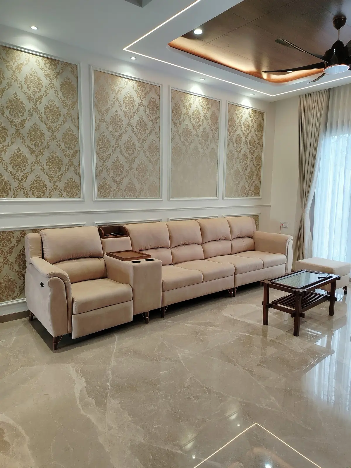 Beige 5 seater recliner sofa set with built-in console in a living room with panelled walls