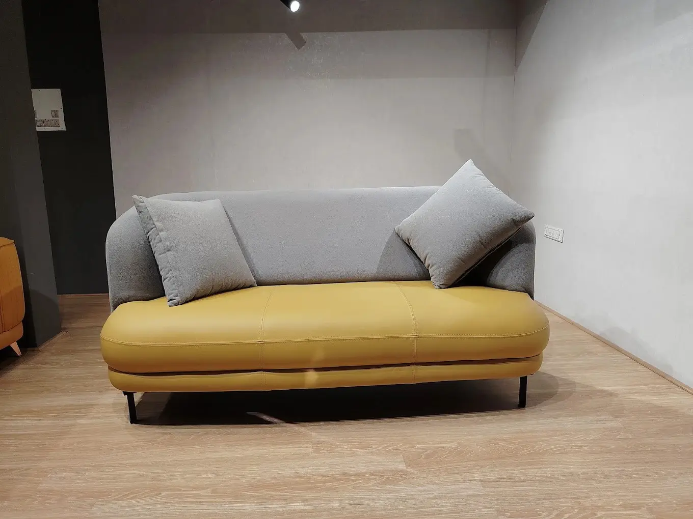 Curved 3 seater sofa with grey back and mustard seat on black metal legs