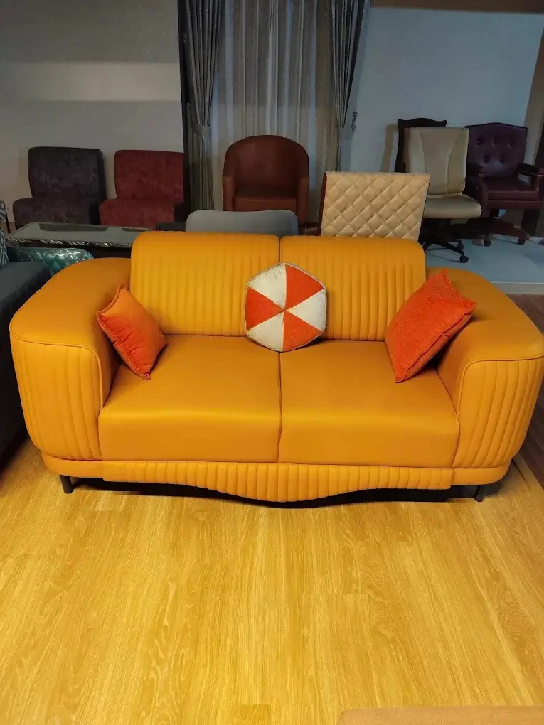 Orange leatherette 2 seater sofa with channel-stitched back and accent cushions