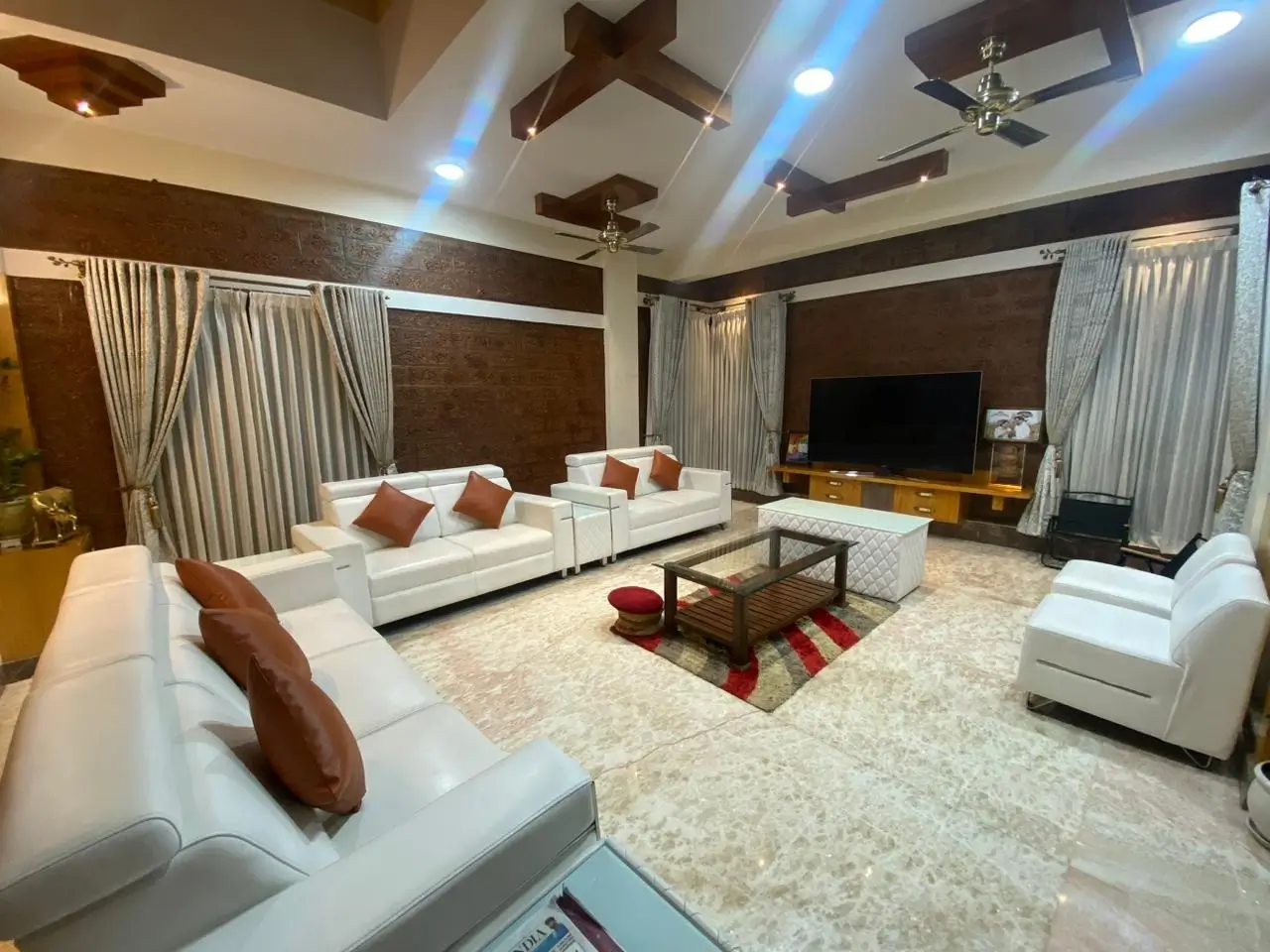 White leather 10 seater sofa set with brown cushions in a spacious living room