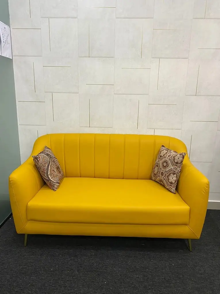 Yellow 2 seater sofa with channel-stitched back and tapered wooden legs